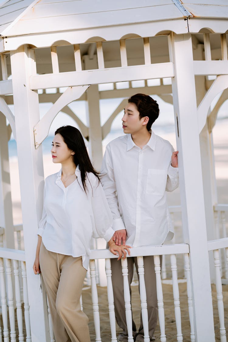 Couple Standing By White Wooden Gazebo