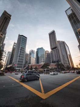 Capture the bustling streets and towering skyscrapers of Singapore's urban skyline at dusk.