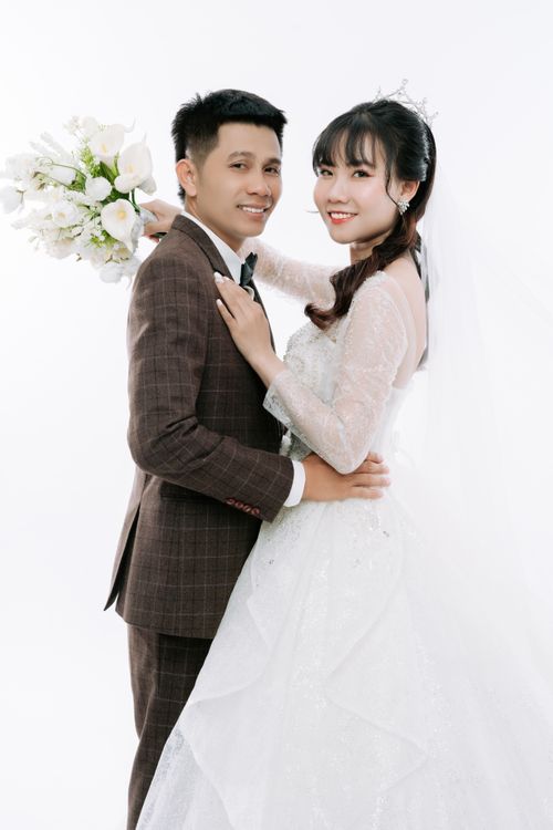 Free Elegant wedding portrait of an Asian couple celebrating their special day with a bridal bouquet. Stock Photo