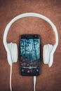 Turned-on Black Samsung Smartphone Between Headphones