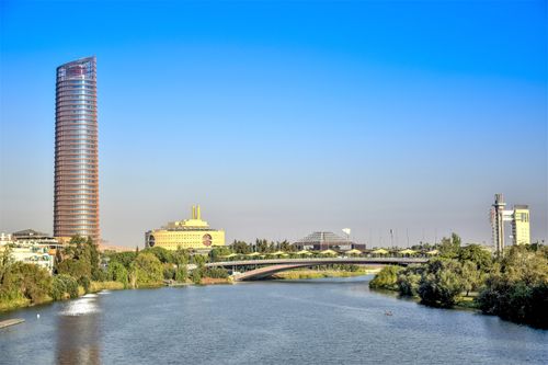 Free View of a modern skyscraper and bridge over the Guadalquivir River in Seville, Spain. Stock Photo