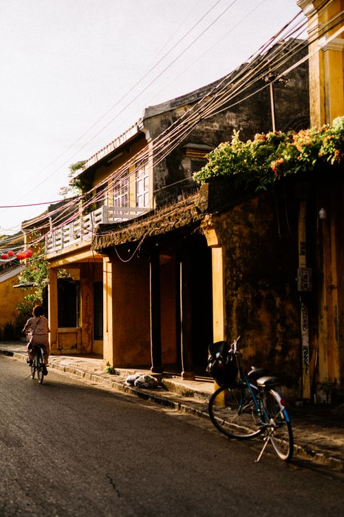 Free A quaint street in Hội An featuring bicycles, old houses, and vibrant greenery. Stock Photo