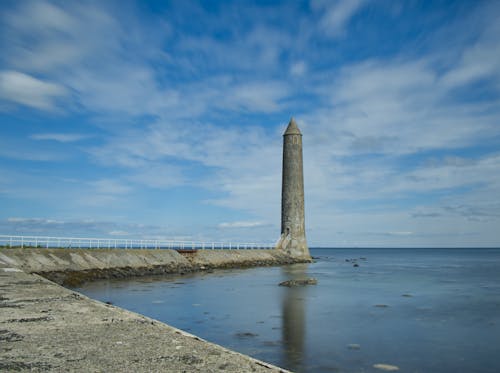 Clouds over Lighthouse on Sea Shore