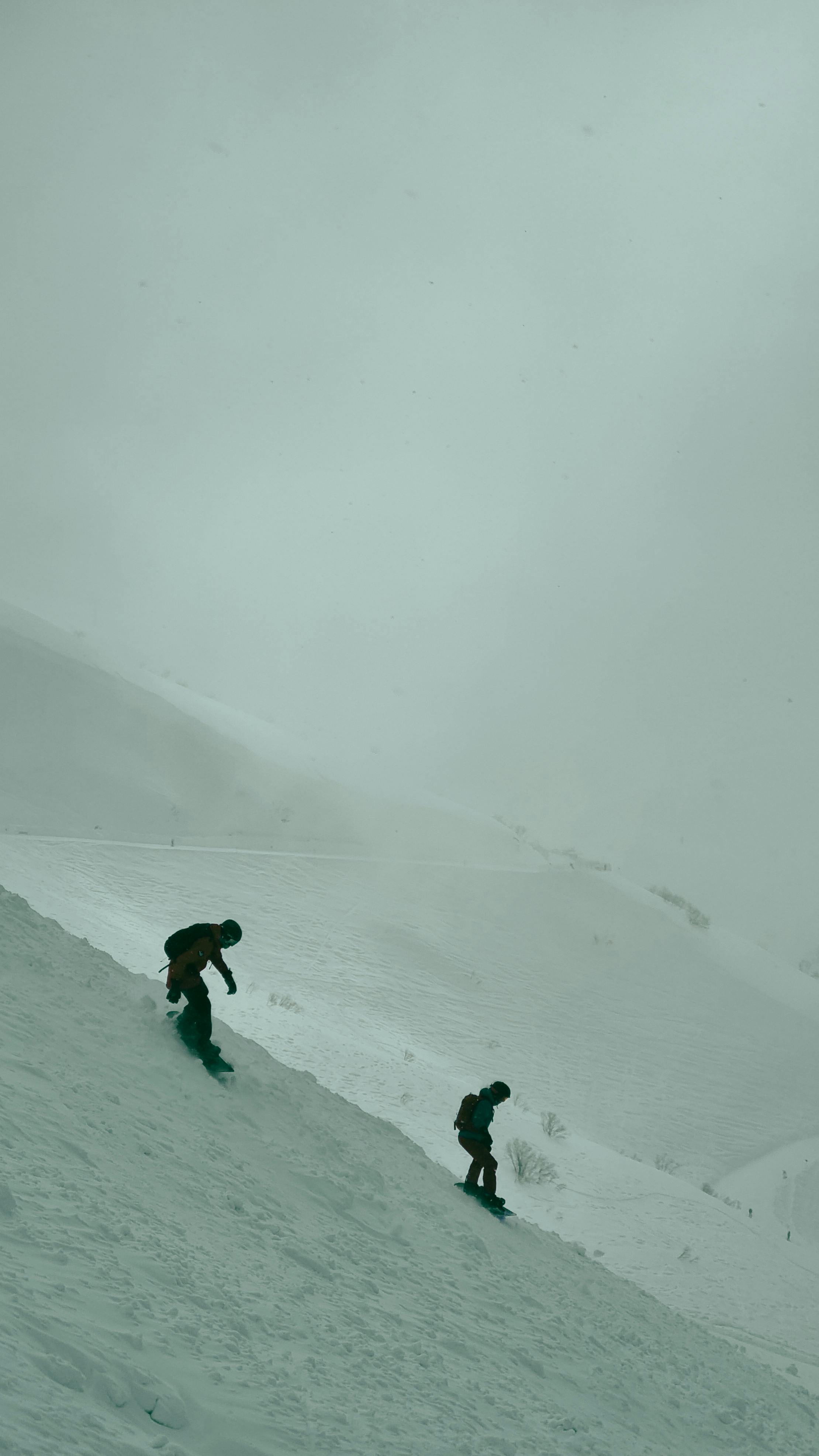 Prescription Goggle Inserts - Two snowboarders navigating a foggy slope in Adlerskiy, capturing the essence of a Russian winter.