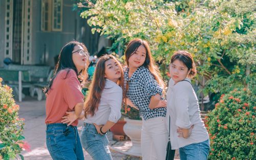Free Group of Asian friends posing playfully outdoors with greenery. Stock Photo