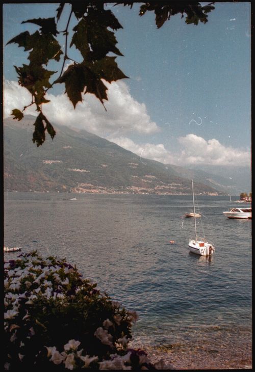 Free Tranquil view of boats on Lake Como with mountainous backdrop under a clear sky. Stock Photo