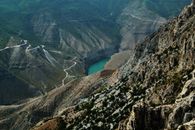 A stunning aerial view of Sulak Canyon in Russia with winding roads and a turquoise river.