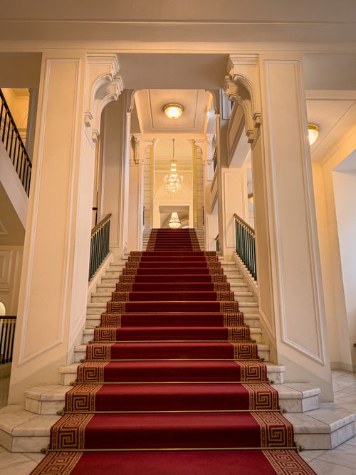 Free Majestic staircase with red carpet in a classic Vienna building interior. Stock Photo