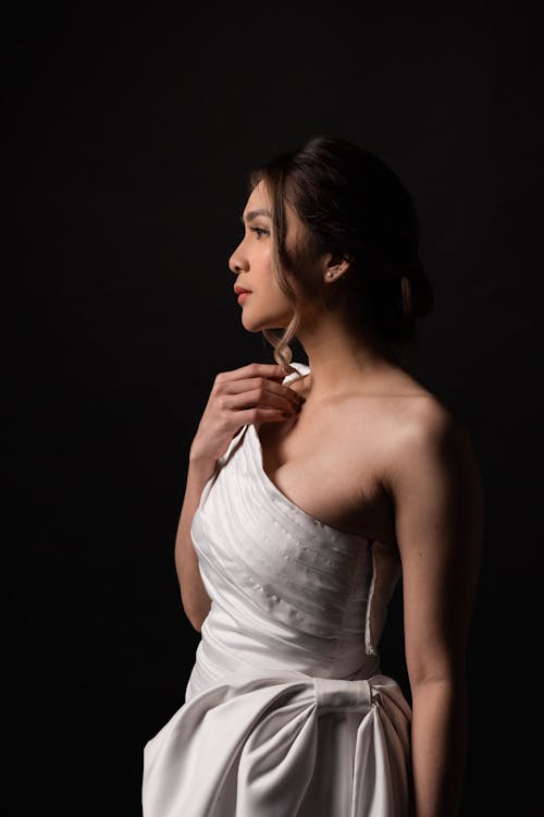 A Woman in White One-Shoulder Dress Posing in the Studio