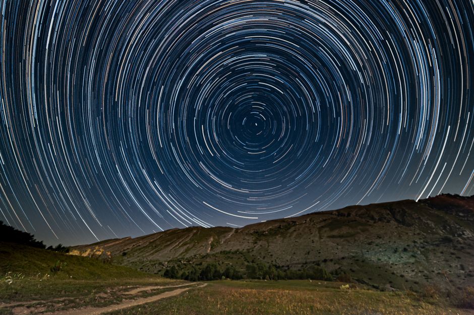 circular star trails over a mountain showing Earth's rotation - best lens star trails circular star trails over a mountain showing Earth's rotation - best lens star trails