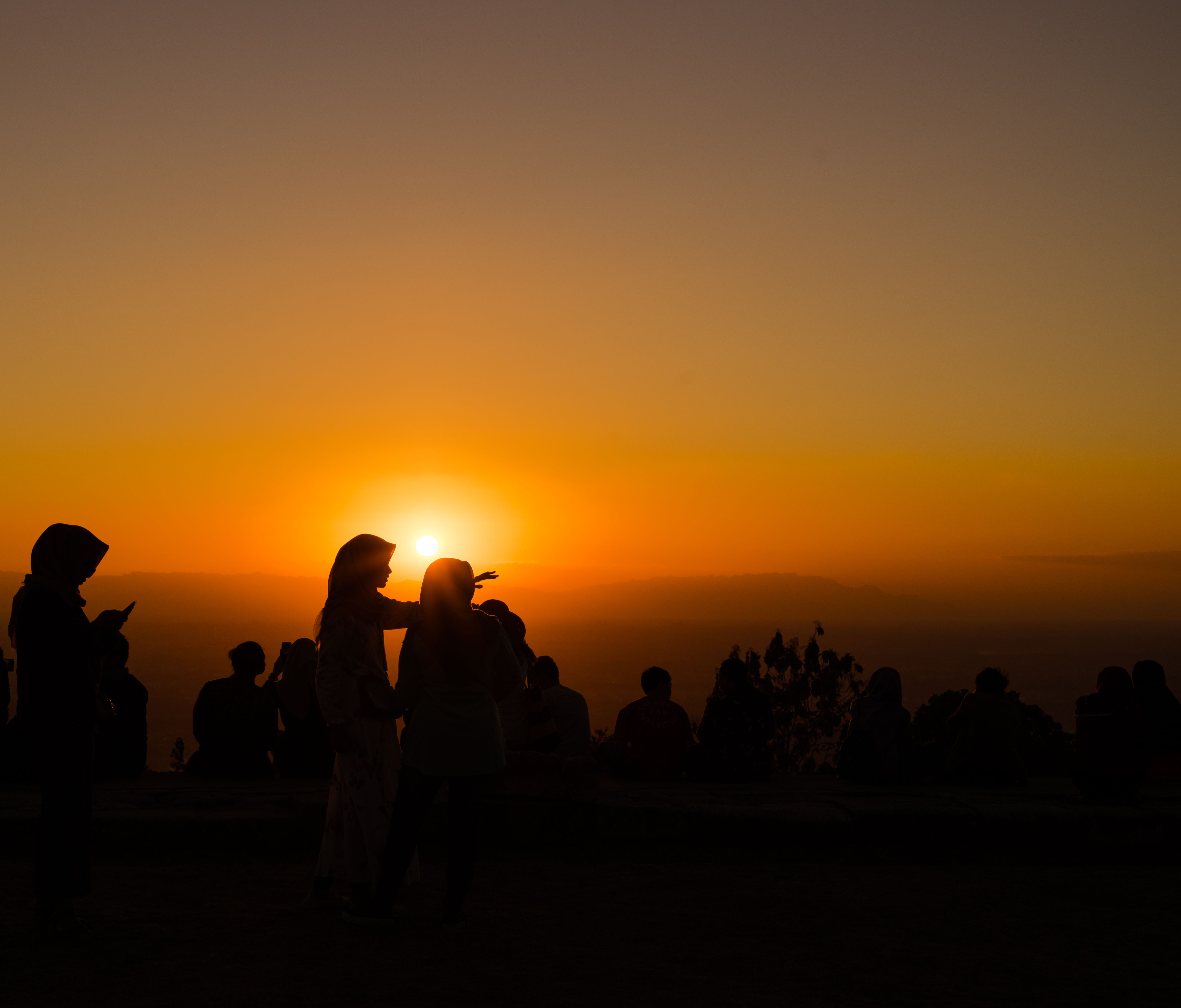 夕阳西下，宁静的剪影中有人正欣赏着这美景