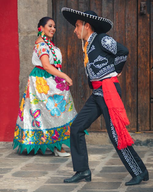 Man and Woman in Traditional Clothes Dancing