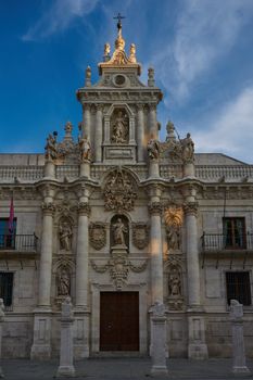 Front view of an ornate historical cathedral facade with detailed sculptures against a clear sky.