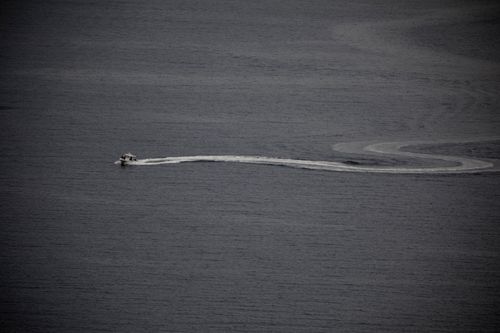 Free Aerial view of a motorboat creating a curved wake in open water, perfect for boating enthusiasts. Stock Photo