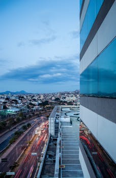 迷人的城市景观包括繁忙高速公路上的灯光步道、现代建筑和黄昏时充满活力的城市天际线