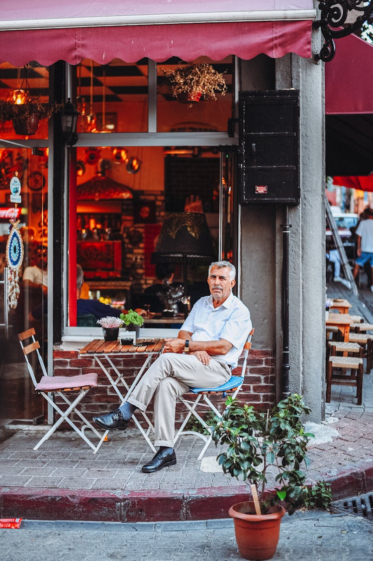 Elderly Man Sitting In A Cafe Patio 