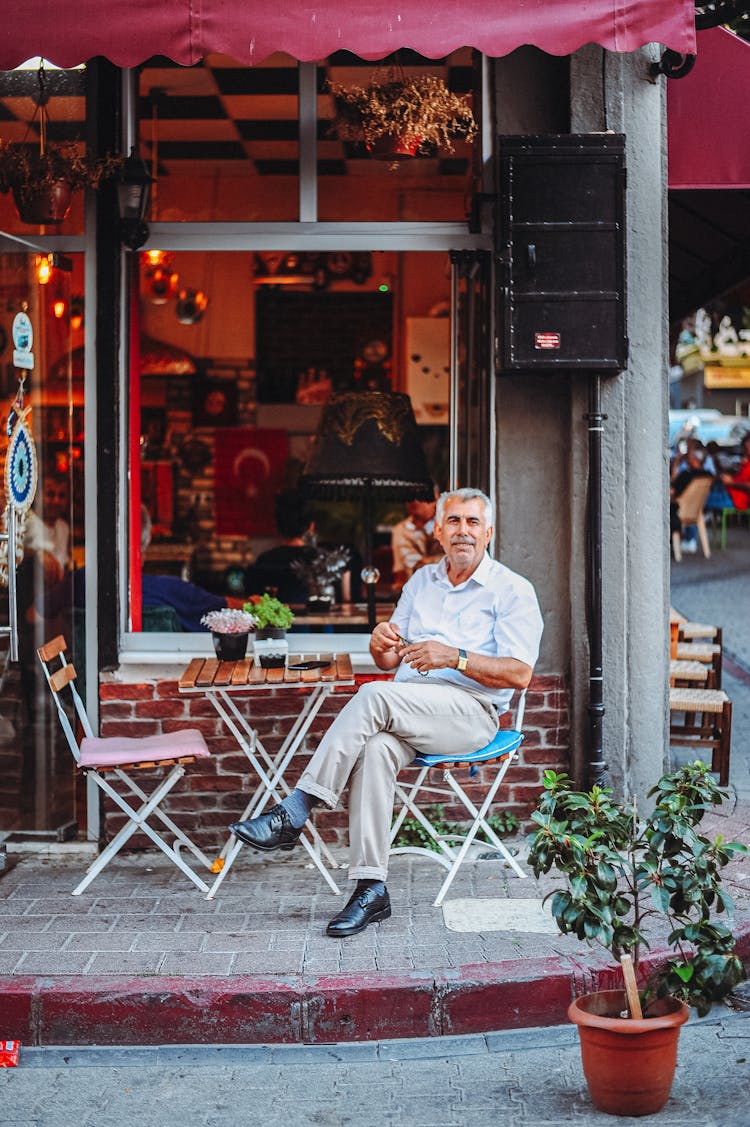 A Man Sitting In Front Of A Bar Restaurant 