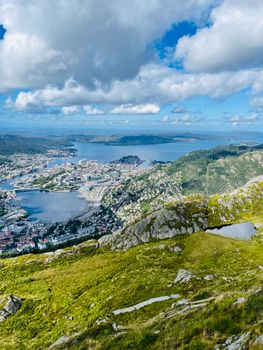 Discover the breathtaking aerial view of Bergen, Norway, showcasing lush landscapes and serene waters under a vibrant sky.