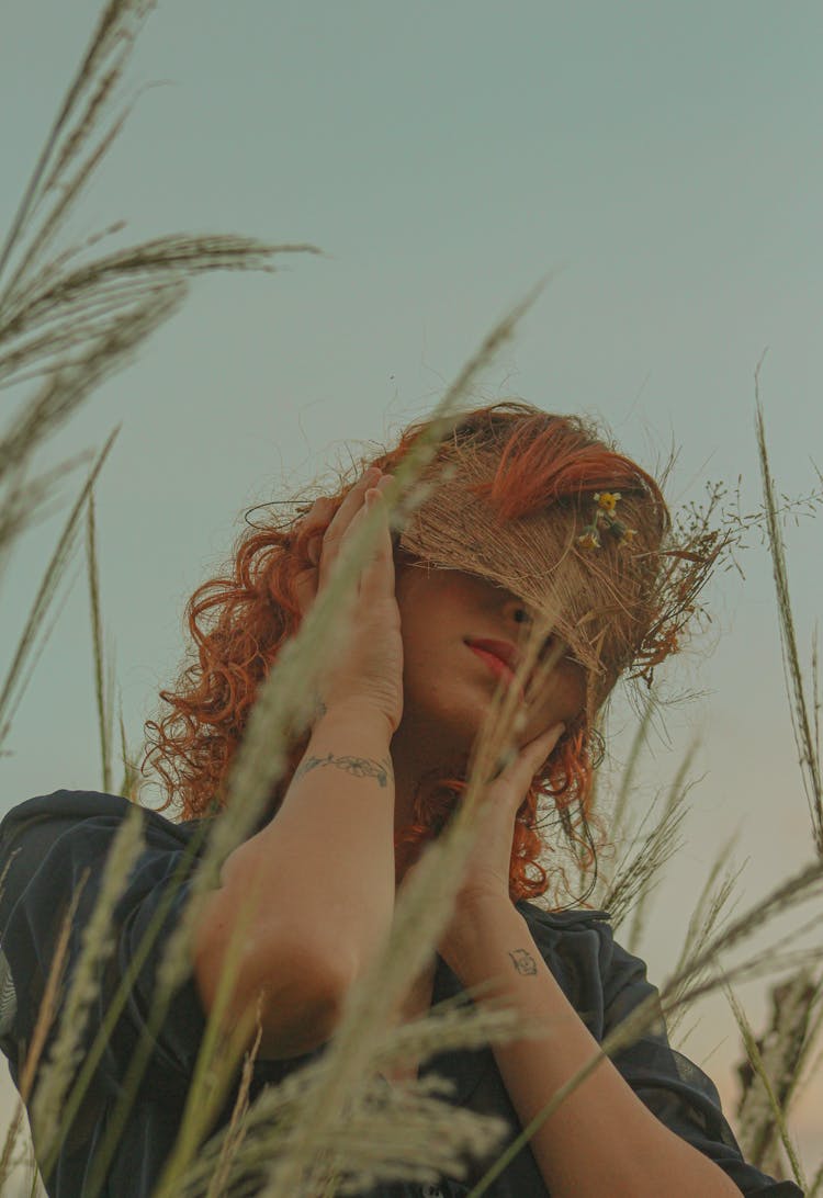 Woman Posing In Grass On Sky Background