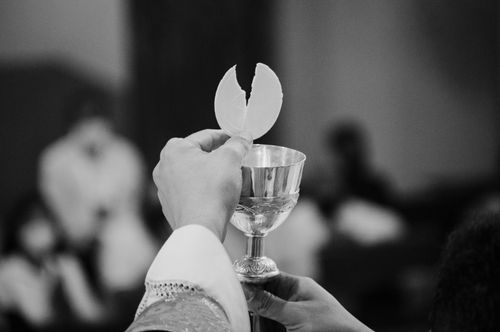 Free Close-up of a communion wafer held by a priest in a religious ceremony. Stock Photo