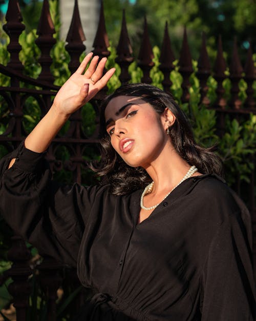 A Woman in Black Long Sleeve Dress Wearing a Pearl Necklace