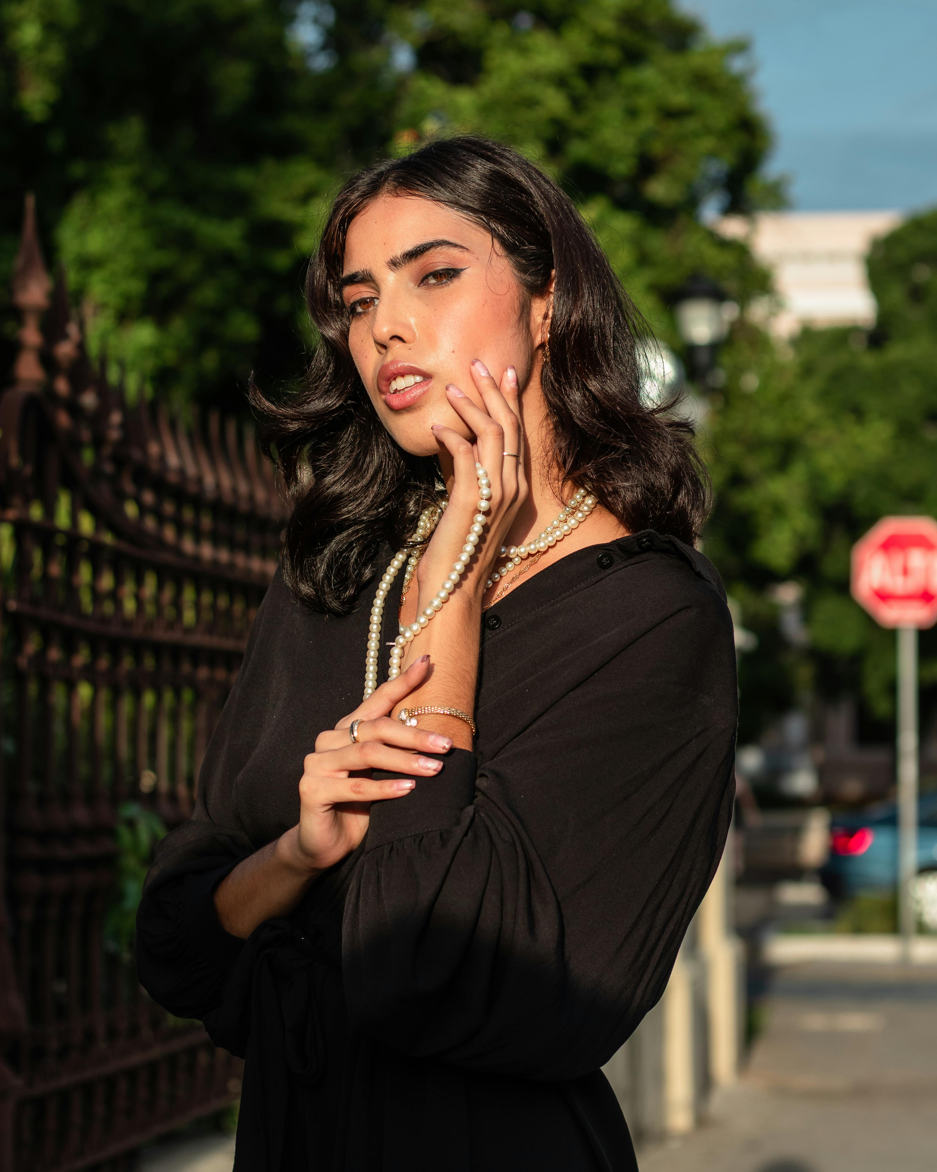 Woman Posing against a Red Rosebush · Free Stock Photo