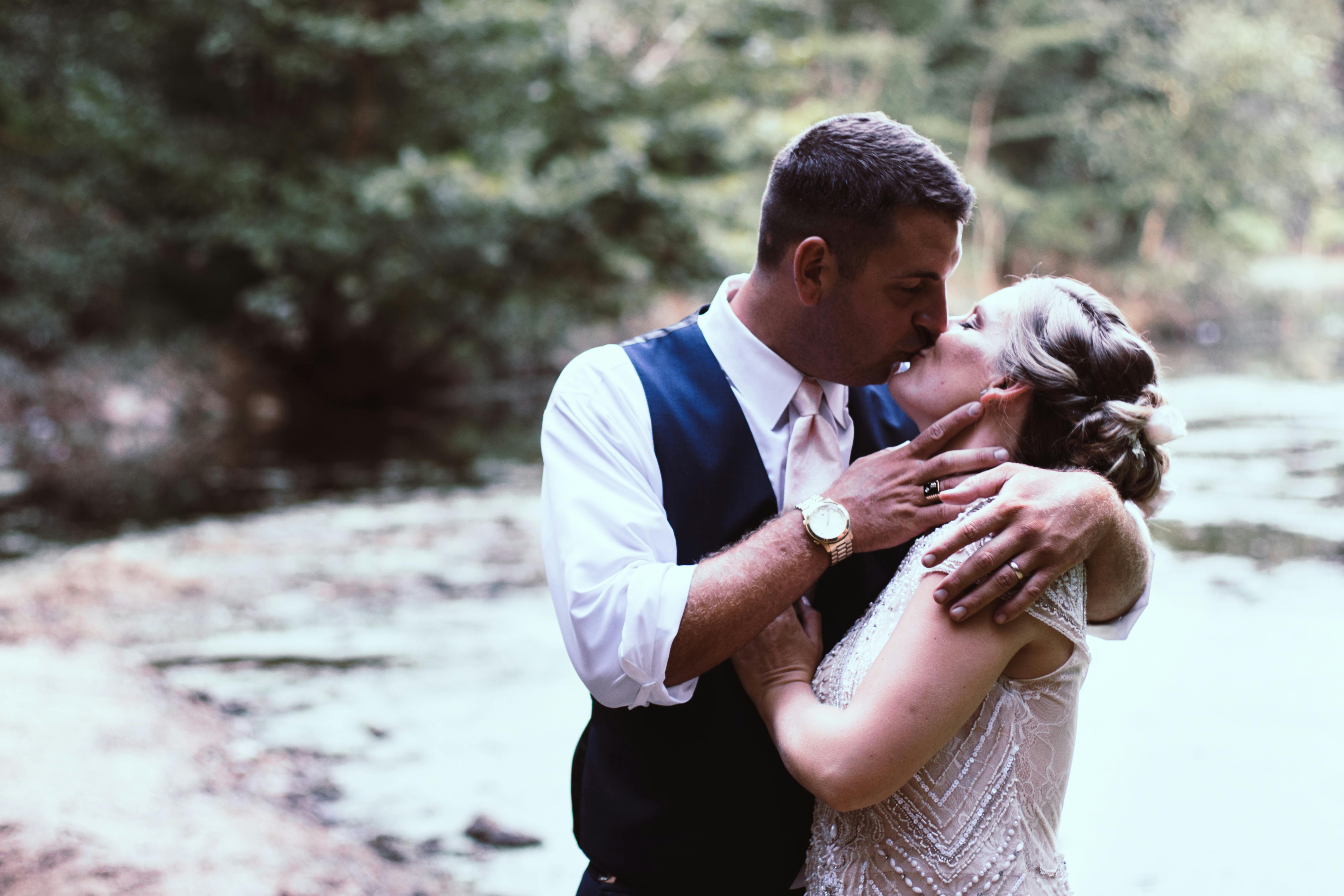 一对恩爱的夫妇在风景优美的河边温柔地接吻