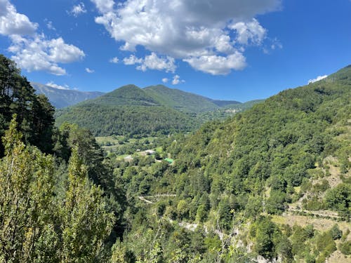 An Aerial Photography of Green Trees on Mountain Under the Blue Sky and White Clouds