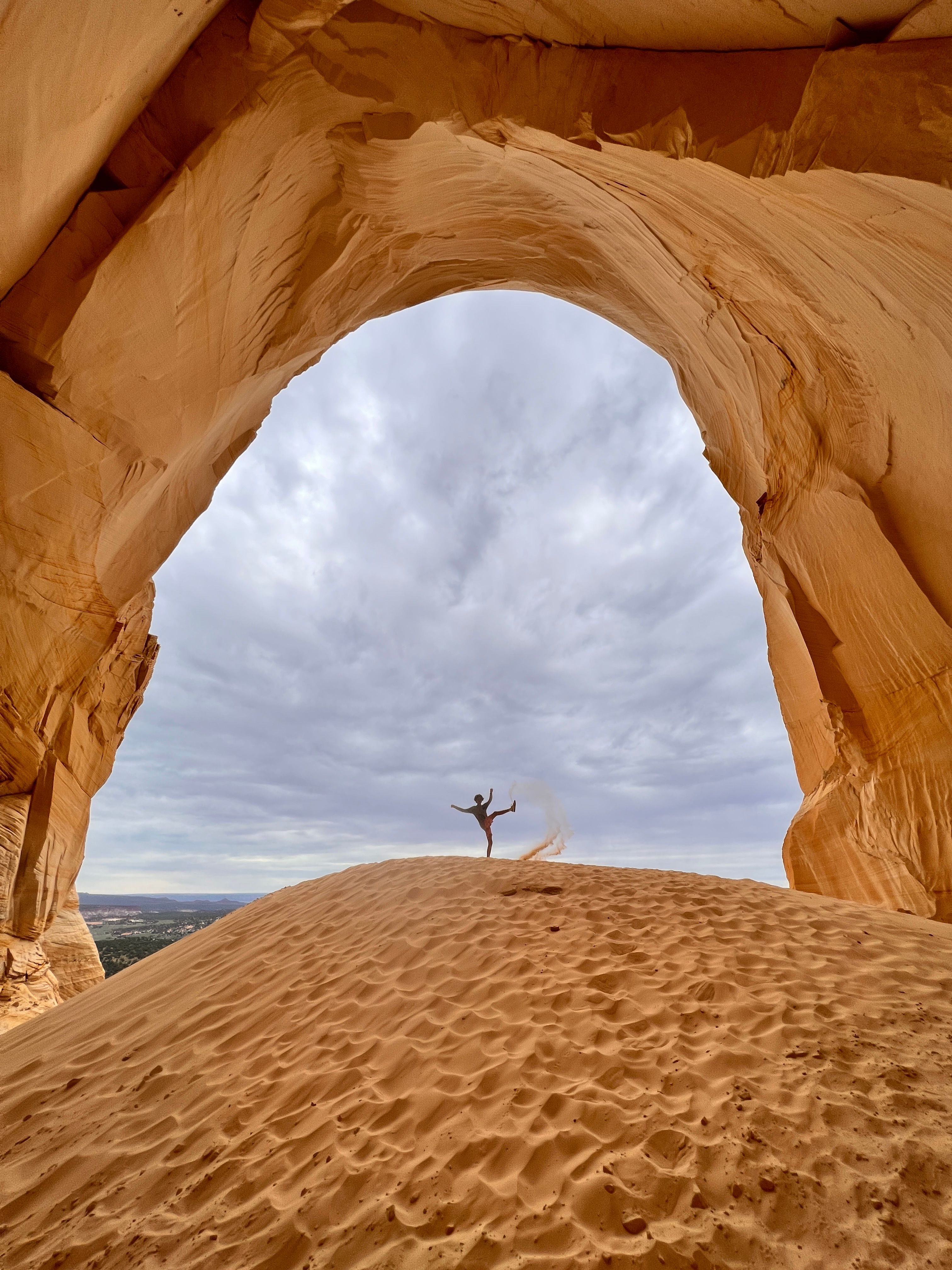 Person Standing on Brown Sand Under Rock Formation · Free Stock Photo
