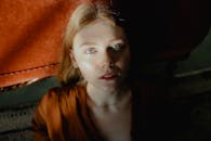 这是一幅迷人的肖像，描绘了一位拥有绿色眼睛的年轻女子，沐浴在戏剧性的室内灯光中