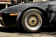 Detailed close-up of a vintage car wheel with a distinctive golden rim.