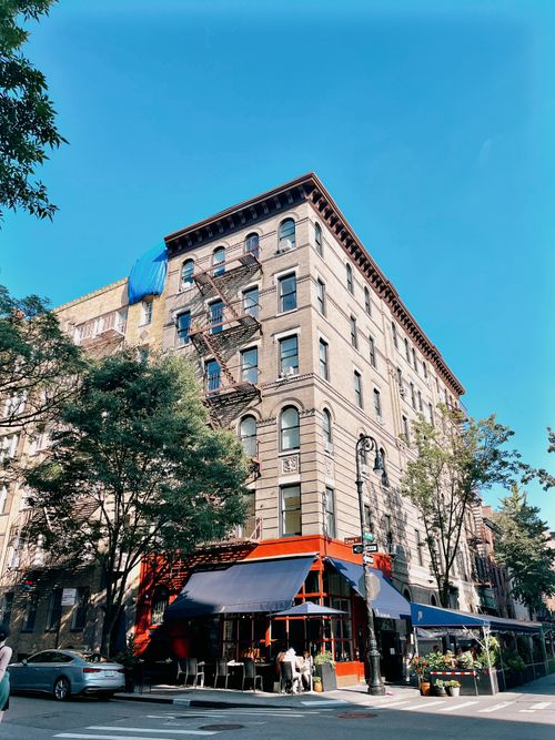 Free Historic building on a sunny New York City street with a café and urban scenery. Stock Photo