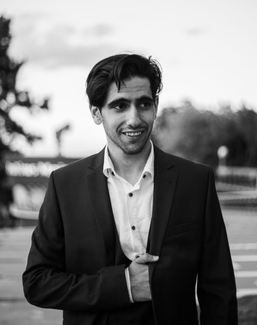 Free Black and white portrait of a smiling man in a suit outdoors. Stock Photo