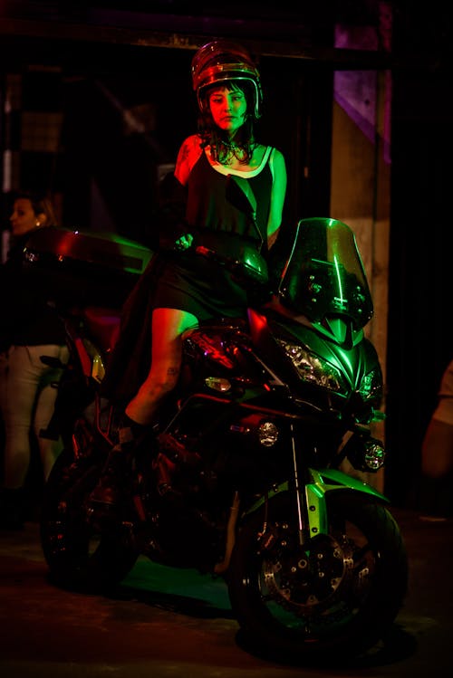 A Woman in Black Dress Riding a Motorcycle