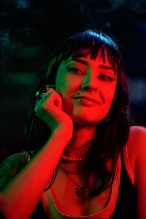 Free A striking portrait of a woman with colorful lighting and expressive gaze. Stock Photo