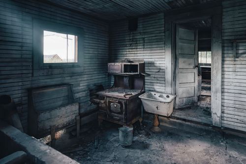 Free A cozy yet eerie abandoned room with vintage furniture and signs of decay. Stock Photo