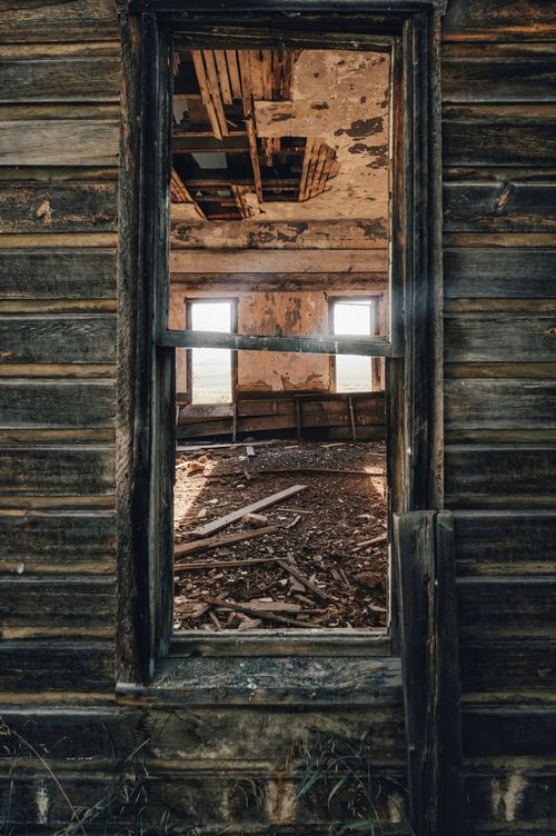 Free Explore the decay of an old wooden structure with broken windows and a ruined interior. Stock Photo