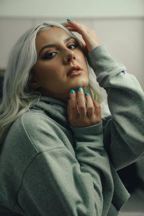 Woman with Nose Piercing Wearing Gray Hoodie while Looking at the Camera