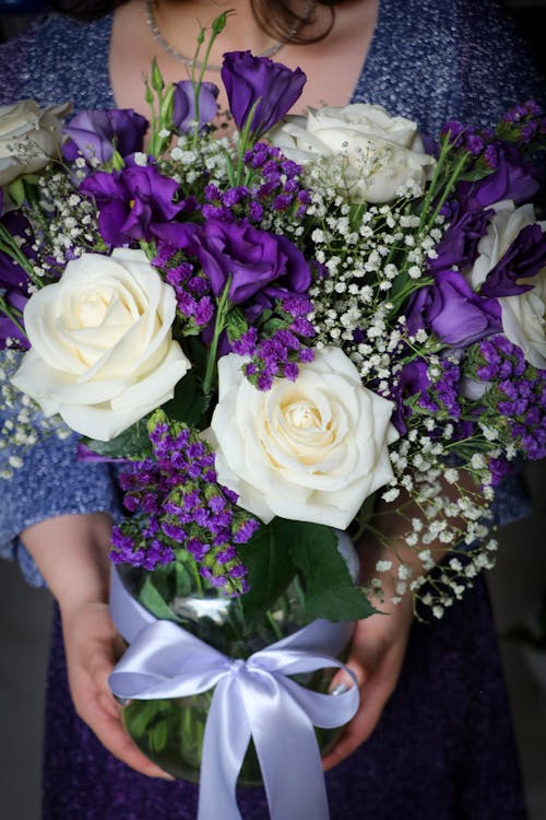 A Person Holding a White and Purple Flowers