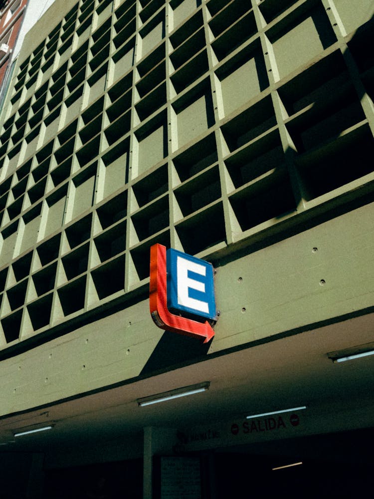 A Letter Signage With Red Arrow On Gray Wall