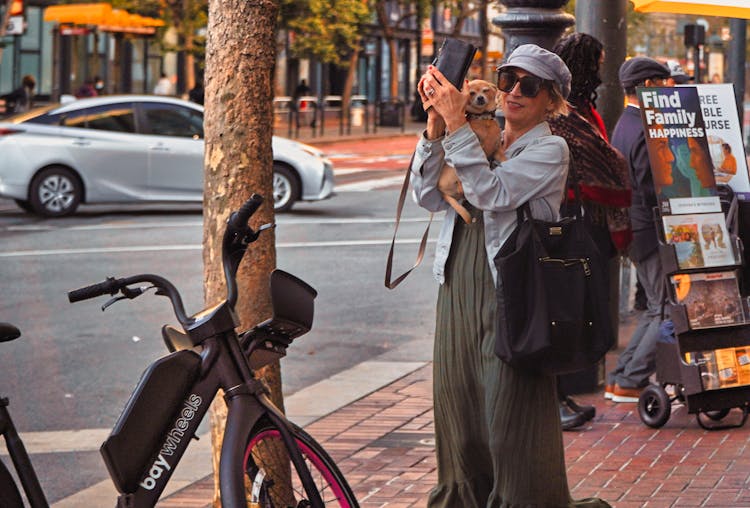 A Woman Carrying A Dog 