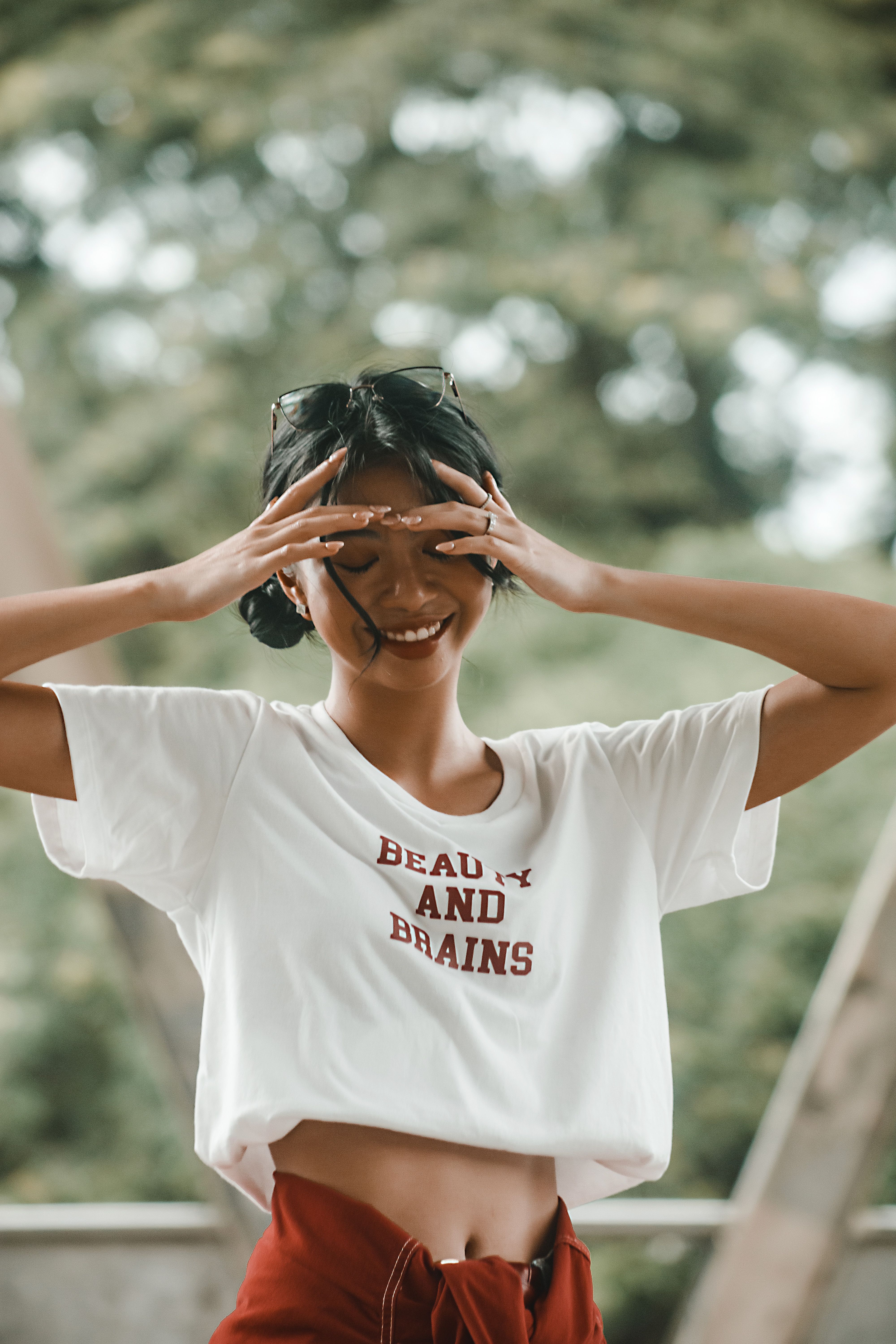 Smiling woman in a stylish graphic tee enjoying a sunny day outdoors.