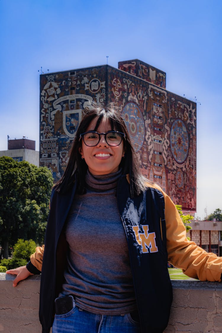 A Woman In Varsity Jacket Smiling At The Camera