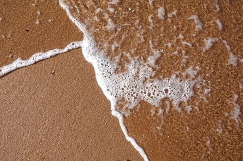 Free Close-up of ocean foam on sand at Dolphin Coast, KZN, South Africa. Stock Photo