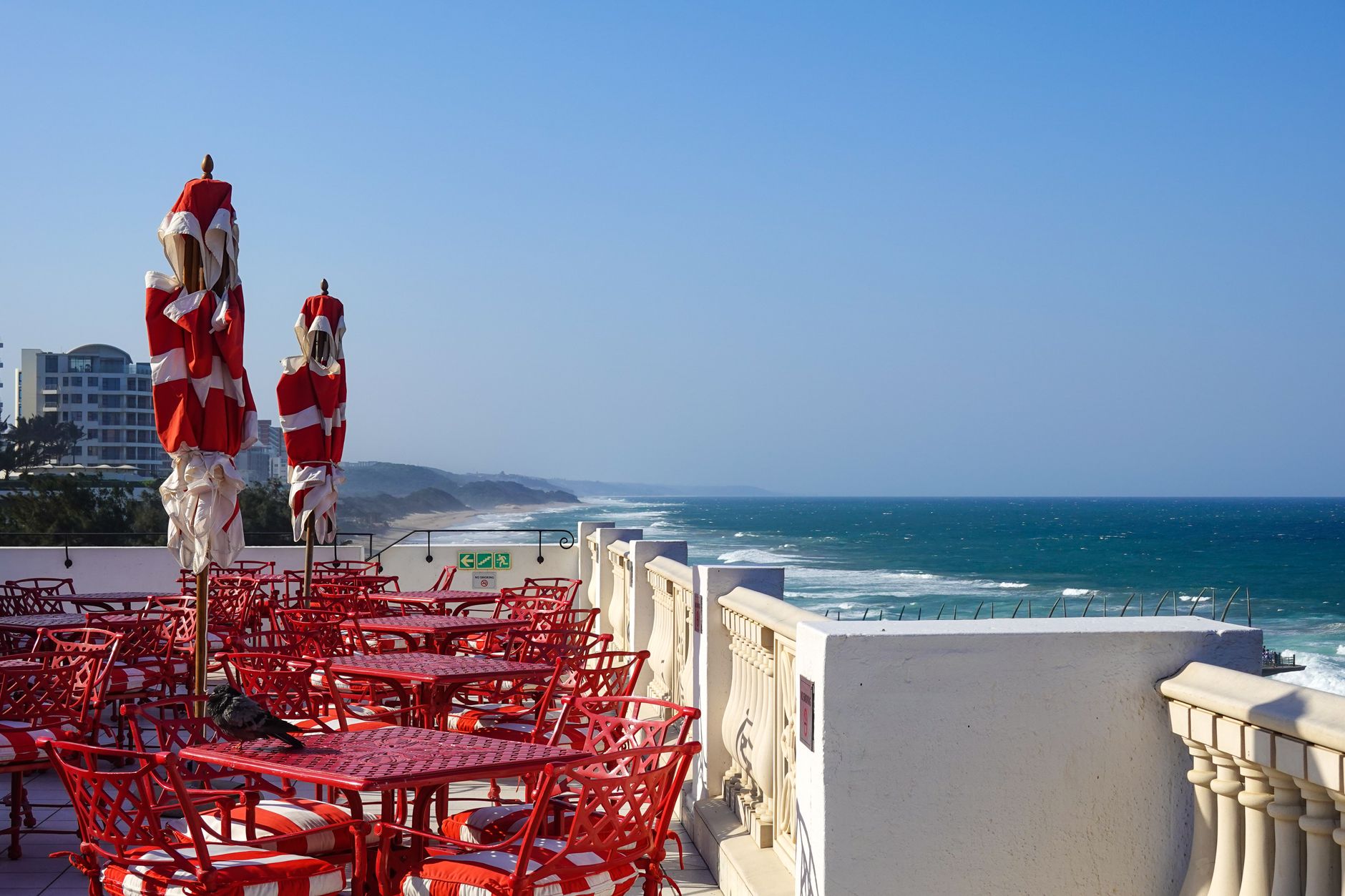 Red furniture on a seaside terrace with ocean views in Umhlanga, South Africa. Related image for Hospitality in Africa: What Is Changing Across Global Hospitality.
