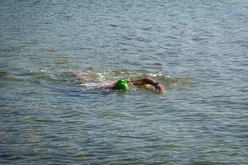 Free Swimmer with a green cap enjoying ocean recreation in Dolphin Coast, KZN. Stock Photo