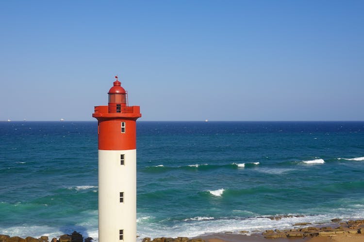 Seascqape With A Red And White Lighthouse