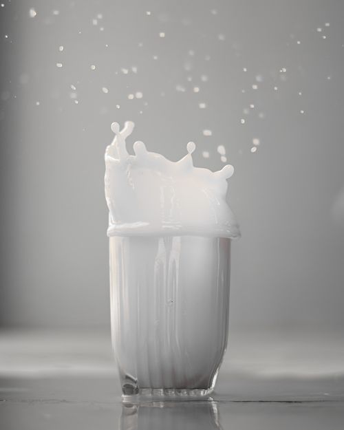 Free High-speed capture of milk splashing over the rim of a glass, showcasing motion and fluid dynamics. Stock Photo