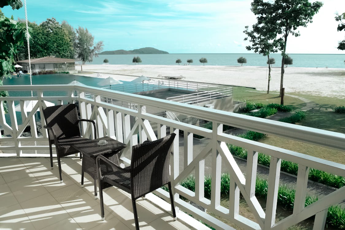 免費 黑色柳條小酒館設置在海洋附近的白色露台上 圖庫相片
