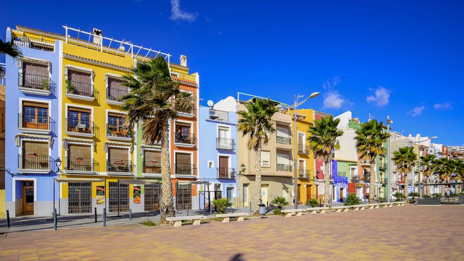 Vibrant colorful buildings on a sunny street in Villajoyosa, Spain.
